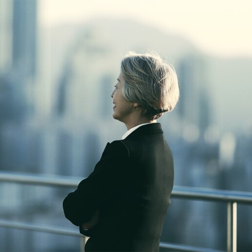 Business professional looking out over a city skyline, reflecting on strategic decisions.
